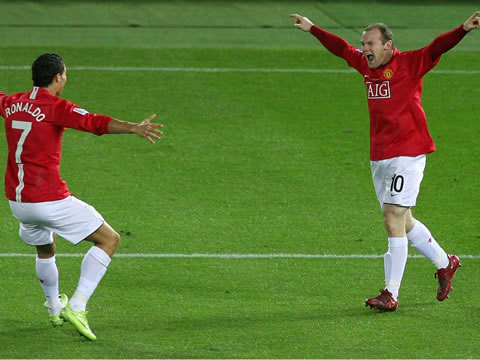 Wayne Rooney and Cristiano Ronaldo running into each other with arms wide, in the UEFA Champions League celebration