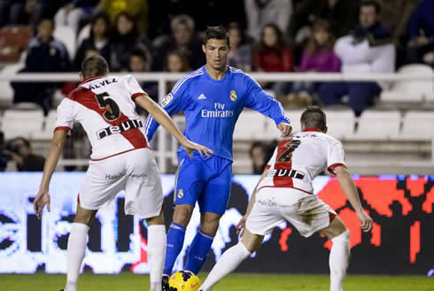 Cristiano Ronaldo trying to get past two defenders right between them, in Rayo Vallecano vs Real Madrid