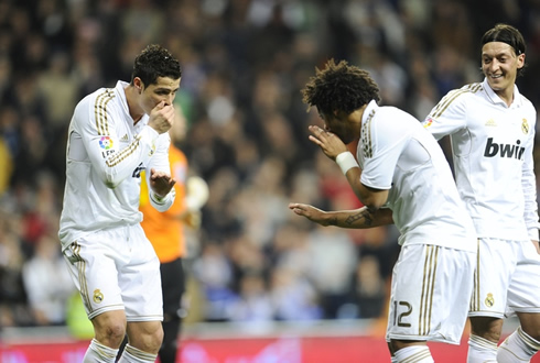 Cristiano Ronaldo and Marcelo funny celebration with their hands on their mouths, as Ozil smiles at it