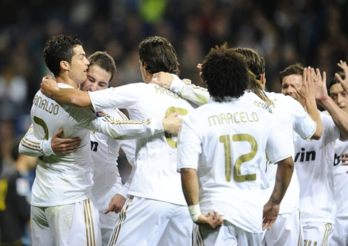 Cristiano Ronaldo hugged to Higuaín and Khedira, as other Real Madrid players prepare to join them in the celebrations