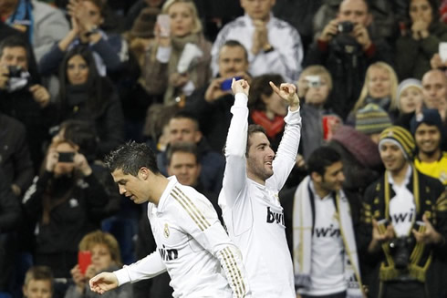 Cristiano Ronaldo returning to Real Madrid's half, as Higuaín interacts with the Bernabéu crowd