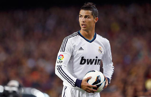 Cristiano Ronaldo holding the football with his two hands, in Barça vs Real Madrid in 2012-13