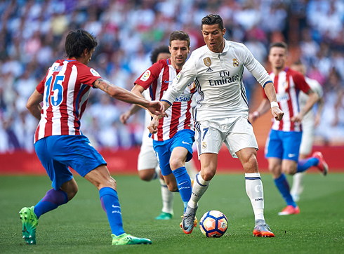 Cristiano Ronaldo surrounded by multiple Atletico Madrid players in the league's derby