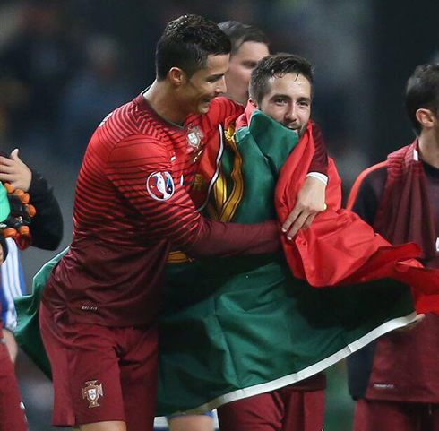 Cristiano Ronaldo hugs a João Moutinho wrapped up in a Portuguese flag