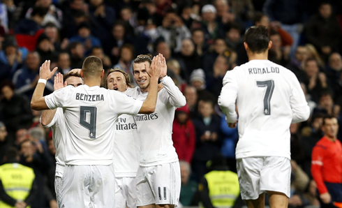 Cristiano Ronaldo runs towards a pack of Real Madrid players, after the home team scores a goal at the Bernabéu