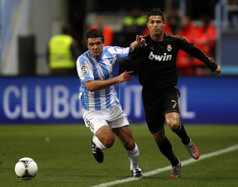 Cristiano Ronaldo sprints as he gets past Toulalan in Malaga vs Real Madrid