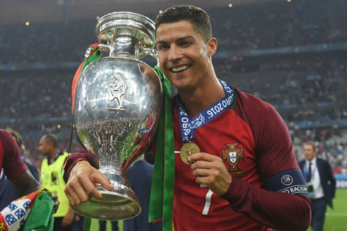 Cristiano Ronaldo holding the EURO 2016 trophy and winner medal