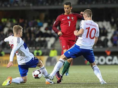 Cristiano Ronaldo tries to get past between two defenders in Faroe Islands vs Portugal