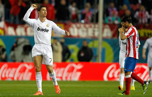 Cristiano Ronaldo raising his right hand when celebrating Real Madrid goal, while Diego passes near him