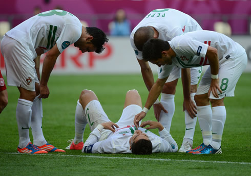 Cristiano Ronaldo on the ground, with Hélder Postiga, Pepe and João Moutinho checking if he is fine, in the EURO 2012