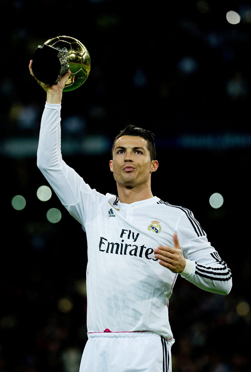 Cristiano Ronaldo lifting the FIFA Ballon d'Or high in the air so the Real Madrid supporters can take a good look at it