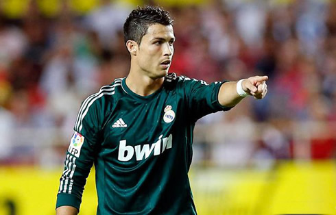 Cristiano Ronaldo pointing to the spot with his right finger, in Sevilla vs Real Madrid, in 2012, wearing a green Real Madrid jersey/uniform kit