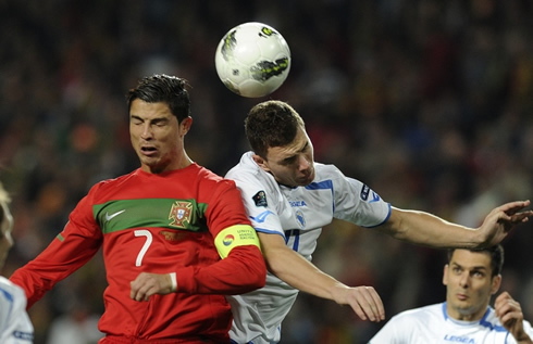 Cristiano Ronaldo jumping and heading a ball with Edin Dzeko from Bosnia
