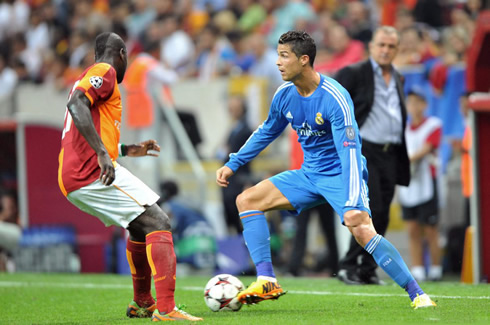 Cristiano Ronaldo prepares to dribble a Galatasaray defender, with Fatih Terim looking at him in second plan