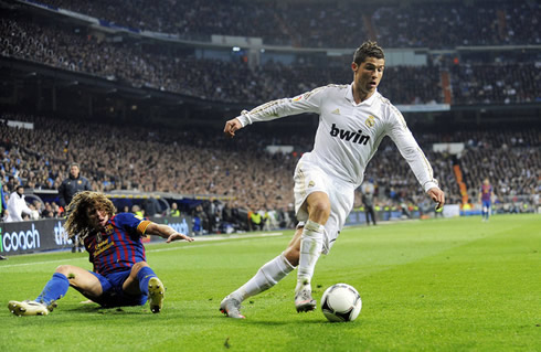 Cristiano Ronaldo takes off, as he leaves Puyol behind him in Real Madrid vs Barcelona, in 2012