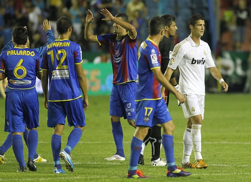 Cristiano Ronaldo walking away as Levante players celebrate their winning goal in the match against Real Madrid, in La Liga 2011-2012