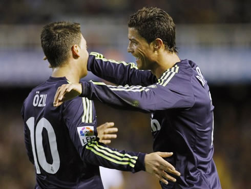 Cristiano Ronaldo about to hug Mesut Ozil, in a Real Madrid game in 2013