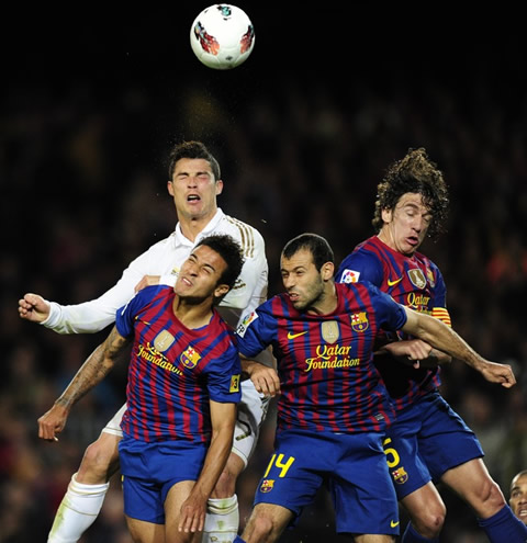 Cristiano Ronaldo and Barcelona players about to make contact with the ball with their hads, but with their eyes closed