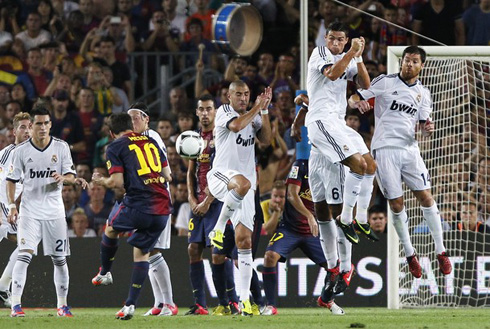 Lionel Messi taking a free-kick and Cristiano Ronaldo jumping higher than anyone else to help blocking the shot, in Barcelona vs Real Madrid in 2012
