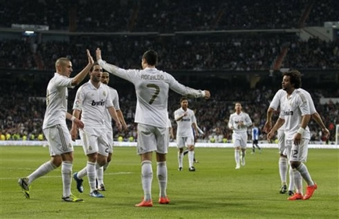 Cristiano Ronaldo and Real Madrid players celebrate a goal together, with the Portuguese player in the middle