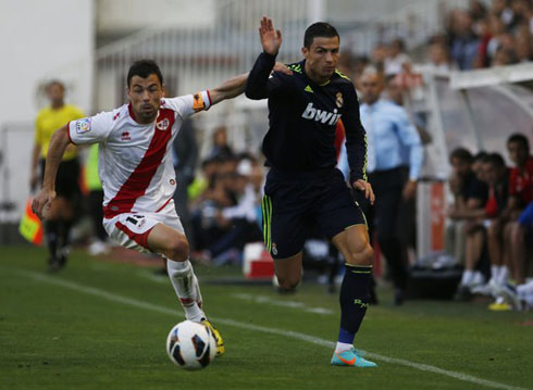 Cristiano Ronaldo running side by side with a Rayo Vallecano defender, in a game for La Liga in 2012-2013