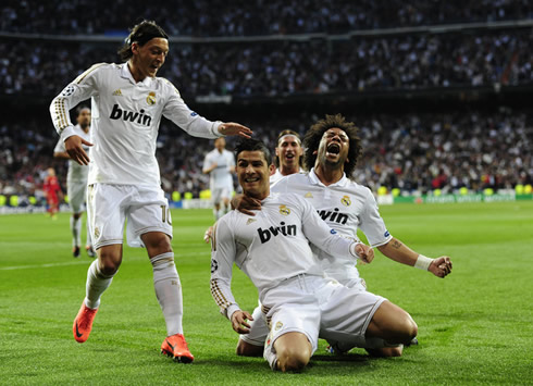 Cristiano Ronaldo and Marcelo sliding on their knees, with Mesut Ozil getting near them, to celebrate Real Madrid goal against Bayern Munich in the UEFA Champions League