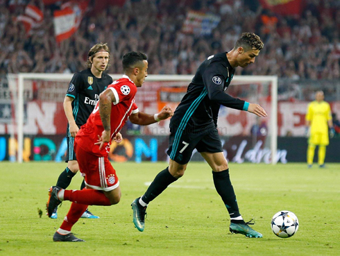 Cristiano Ronaldo preparing to shoot while Thiago Alcantara chases him