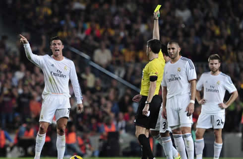 Cristiano Ronaldo being shown a yellow card as he complains and remembers the referee about not having called a penalty-kick on him