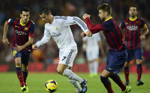 Cristiano Ronaldo being pulled by Gerard Piqué and followed by Sergio Busquets, in Barça 2-1 Real Madrid