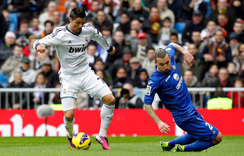 Cristiano Ronaldo dribbling a defender and sending him to the ground, in a game for Real Madrid in 2013