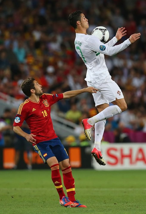 Cristiano Ronaldo big jump to control the ball in the air with his chest, as Jordi Alba looks at it stunned, in Portugal vs Spain, at the EURO 2012