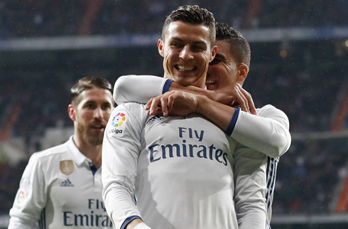 Cristiano Ronaldo smiling as he gets grabbed by Casemiro from behind