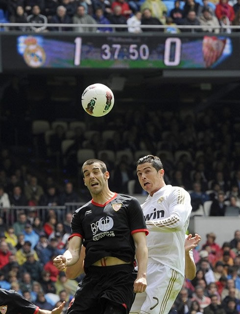 Cristiano Ronaldo and Alvaro Negredo jumping and tyring to head the ball in Real Madrid vs Sevilla, for La Liga 2012
