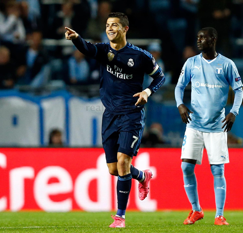 Cristiano Ronaldo smiles and points to his teammate ahead of him, after scoring in the UEFA Champions League