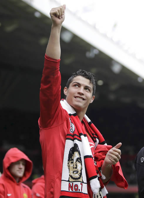 Cristiano Ronaldo celebrating a Manchester United trophy at Old Trafford, with Wayne Rooney behind him