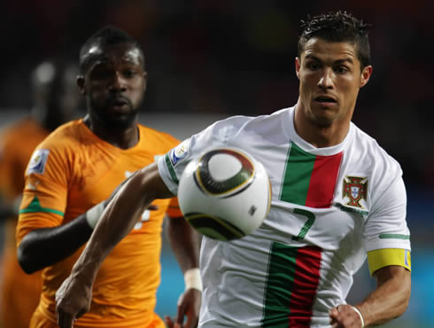 Cristiano Ronaldo in a white Portugal jersey, running very focused after the ball