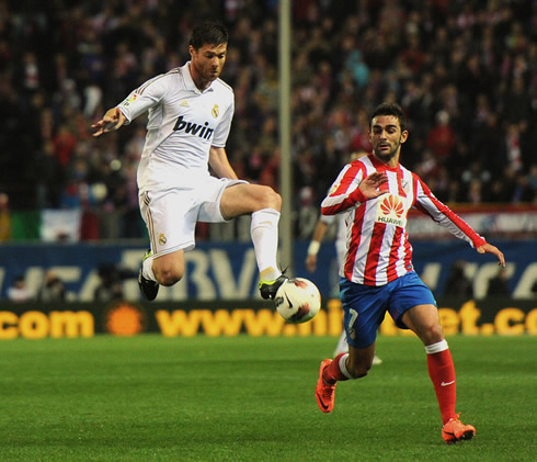 Xabi Alonso passing the ball in the air, in Atletico Madrid vs Real Madrid, in 2012