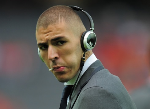 Karim Benzema fashion style in a Real Madrid suit, with an headphones set on his head and a toothpick on his mouth, in 2012