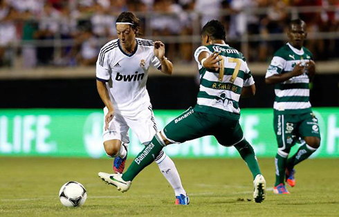 Mesut Ozil dribbling an opponent, in Real Madrid 2012-2013