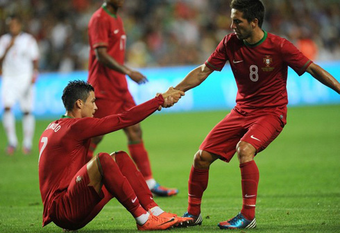Cristiano Ronaldo being helped by João Moutinho, to lift from the floor in a friendly match in 2012