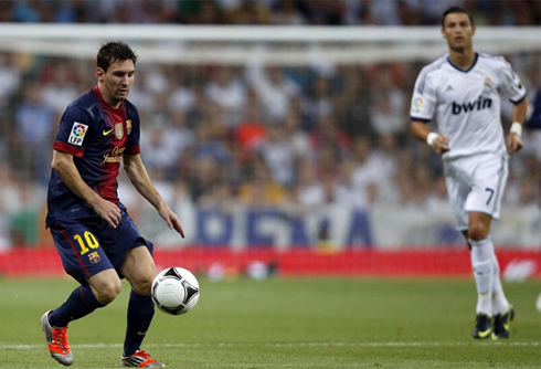Lionel Messi controlling the ball, with Ronaldo getting near from behind, at the Spanish Supercup, in 2012