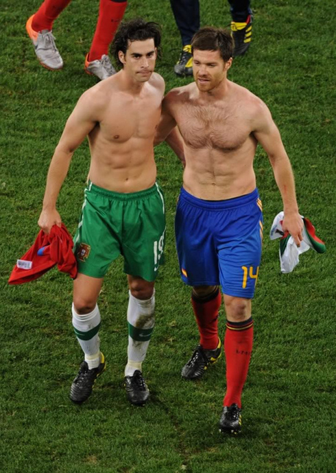 Xabi Alonso without shirt showing off his six-pack abs and walking with Tiago, after a Portugal vs Spain match