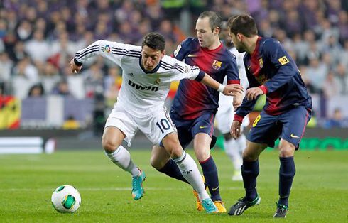 Mesut Ozil playing against Andrés Iniesta and Gerard Piqué, in a Real Madrid vs Barcelona game in 2013