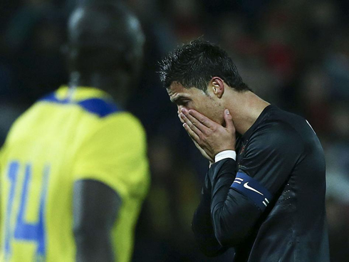 Cristiano Ronaldo putting his hands in front of his face, as he seems ashamed during a game for Portugal in 2013