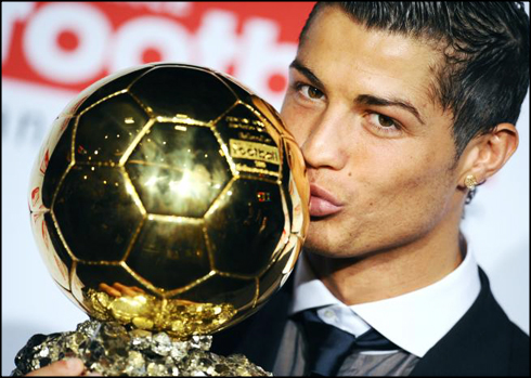 Cristiano Ronaldo kissing the FIFA Ballon d'Or award and trophy