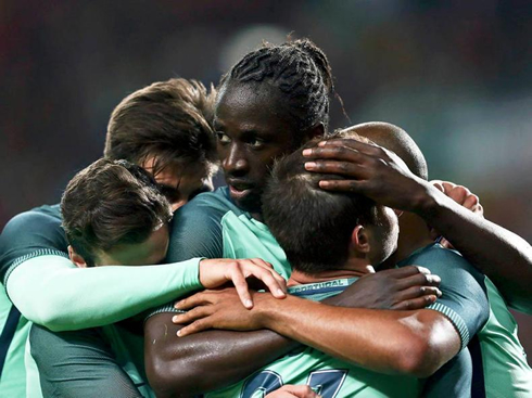 Éder getting hugged by his Portuguese teammates