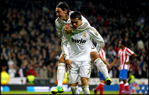 Cristiano Ronaldo with Mesut Ozil on his back, in La Liga 2011-2012