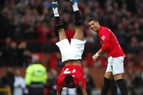 Cristiano Ronaldo laughing while Nani celebrates a goal doing a backflip