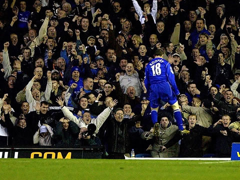 Wayne Rooney suspended in the air as he celebrates a goal for Everton FC, with the crowd going mad