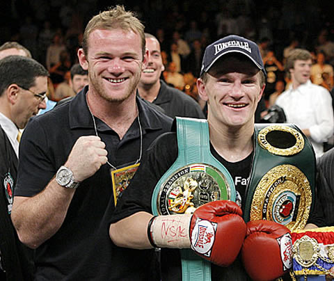 Wayne Rooney taking a photo with a famous boxer, in a boxing event